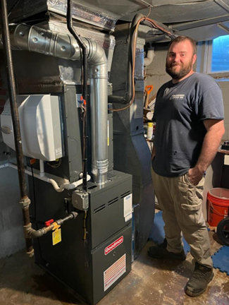 McDaniel technician standing beside a furnace
