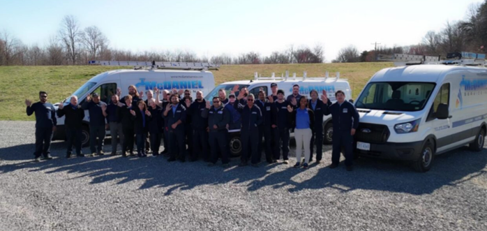 McDaniel team standing in front of service vehicles